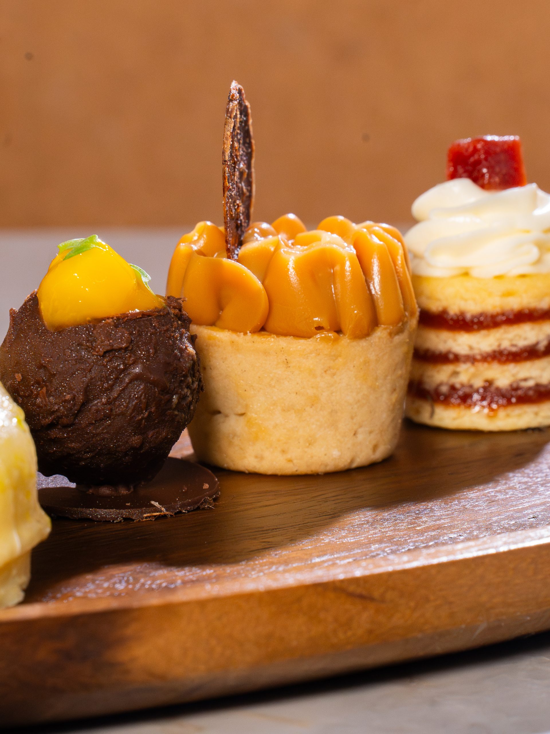 Seleção de doces individuais apresentados em tábua de madeira