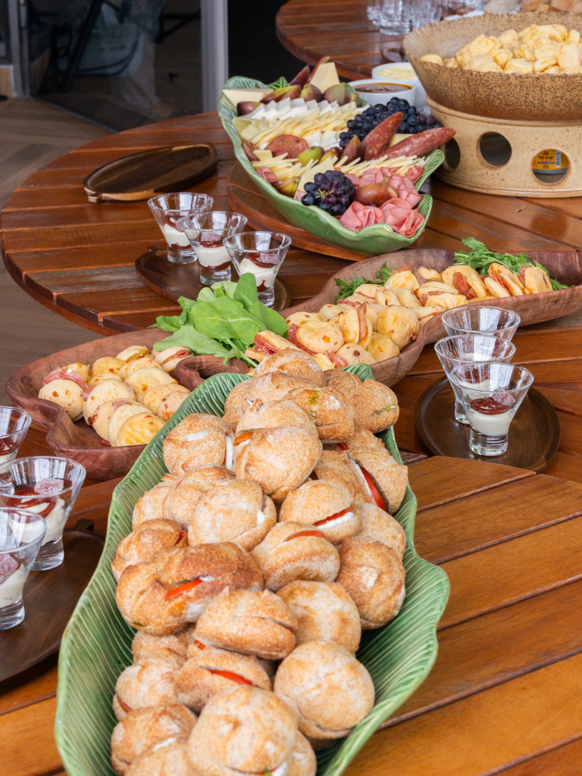 Mesa de coffee break com pães, frios, frutas e acompanhamentos