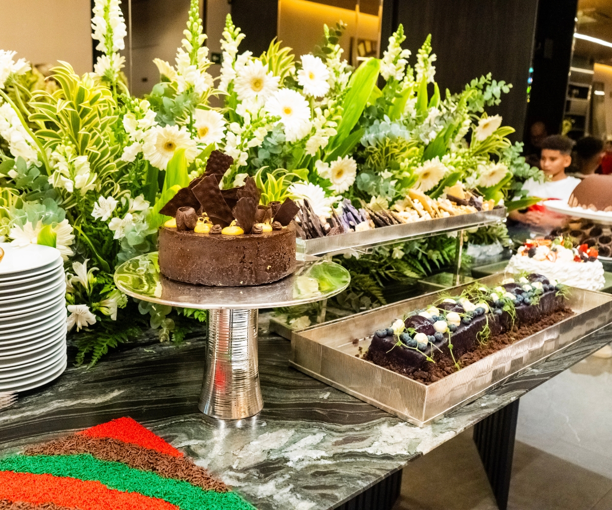 Mesa de catering com doces e apresentação floral
